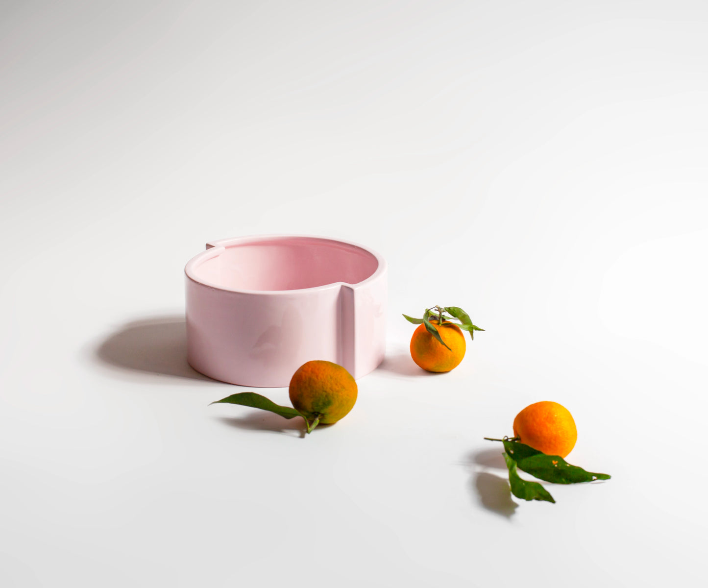 the beautiful pink ceramic "pawn" fruit bowl with three tangerines, offering a fresh color palette for your home decor.