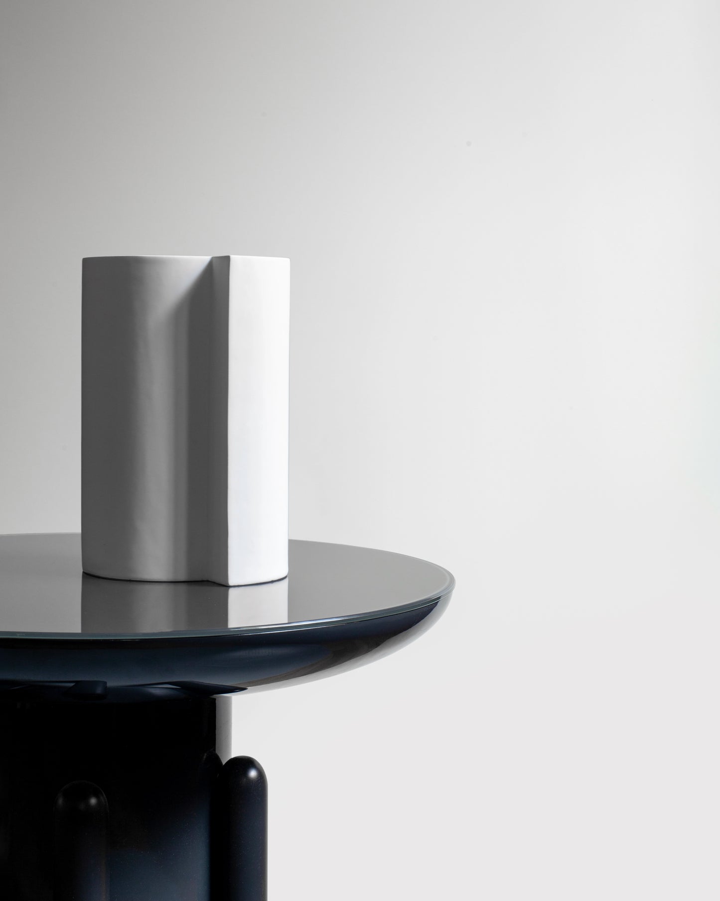 Contemporary white Bishop Vase with geometric shapes and clean lines on a black jaime hayon table