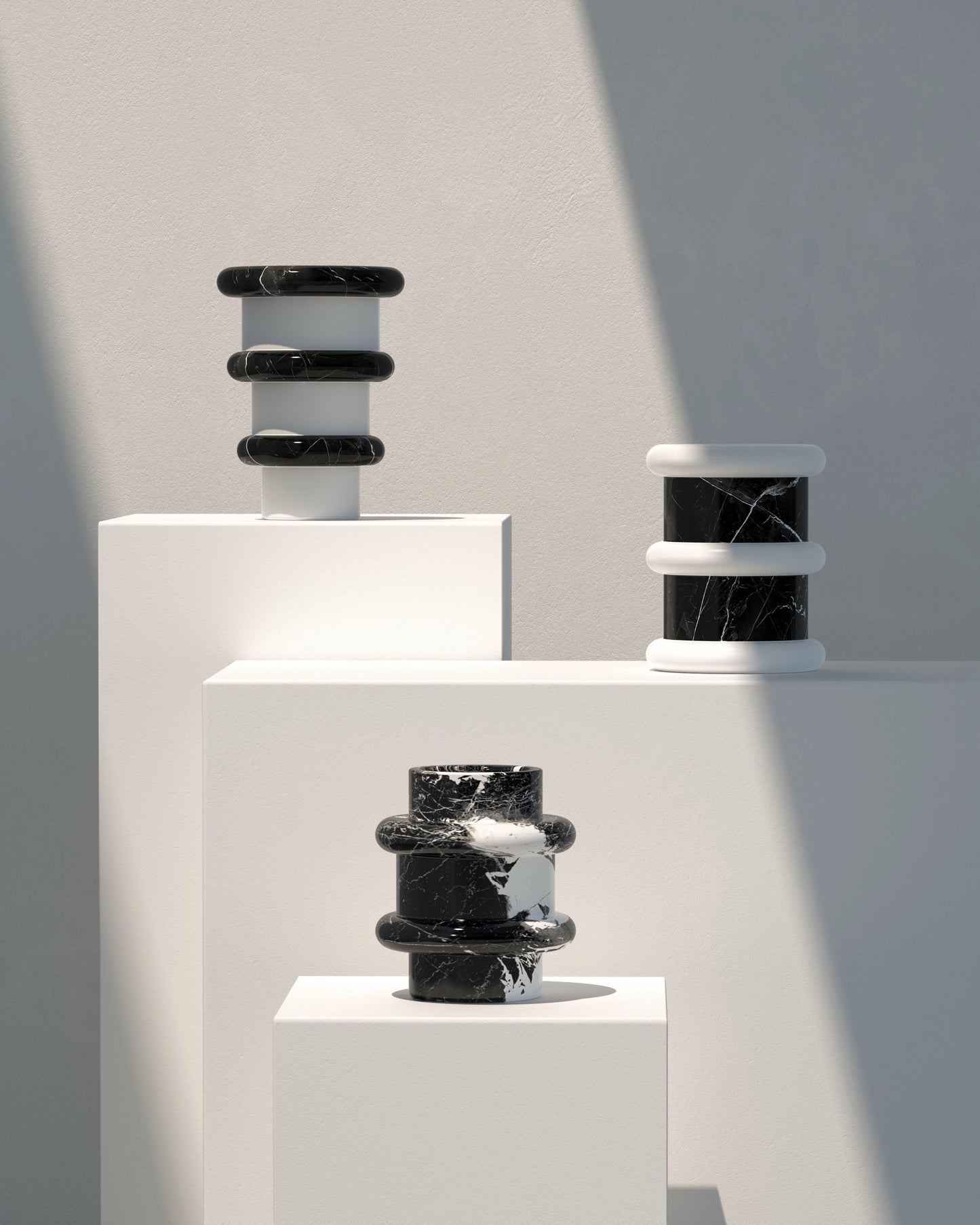 Luxurious Lumière vases in black and white marble on white pedestals arrangement