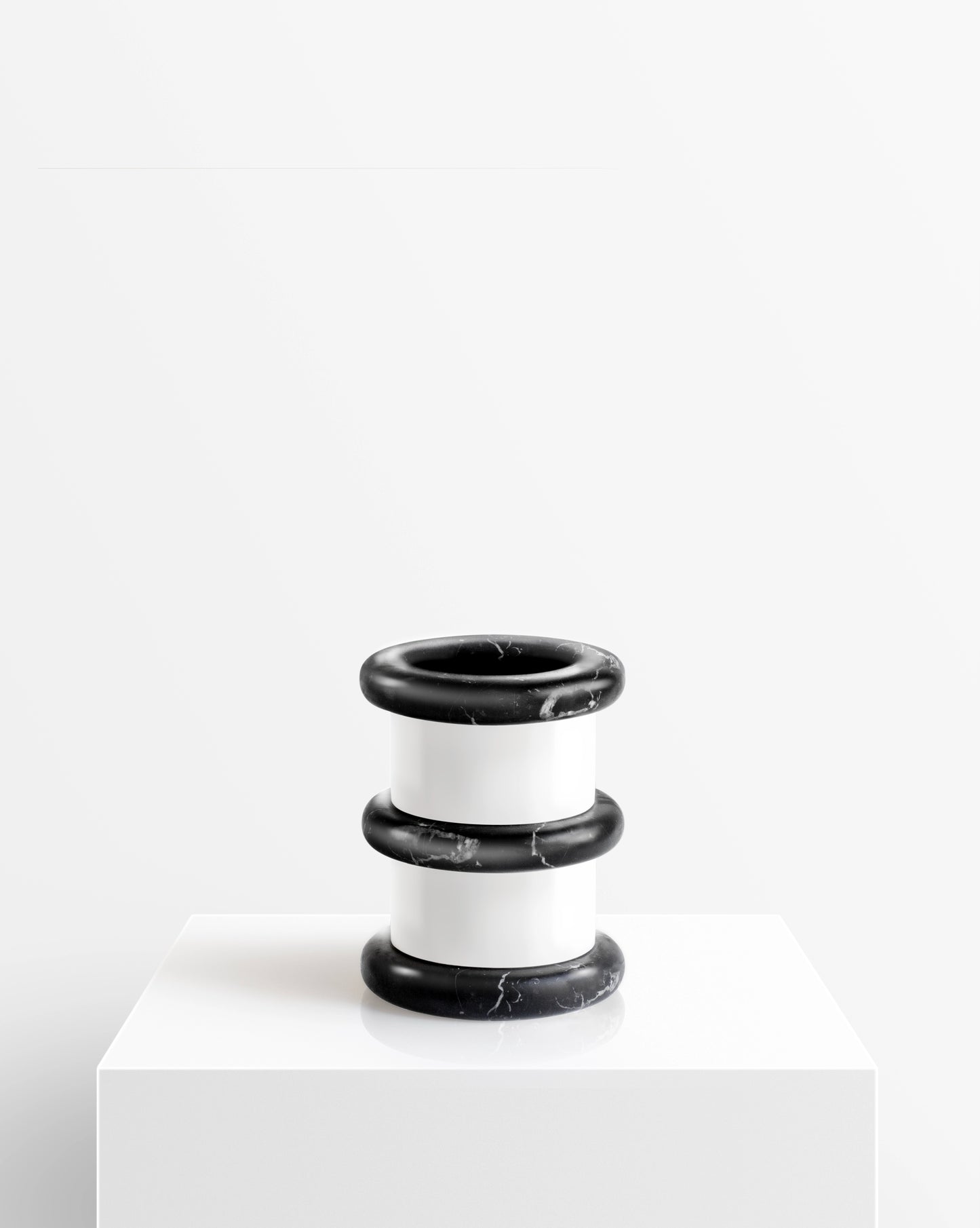 Black and white marble vase from the Lumière collection on a white pedestal