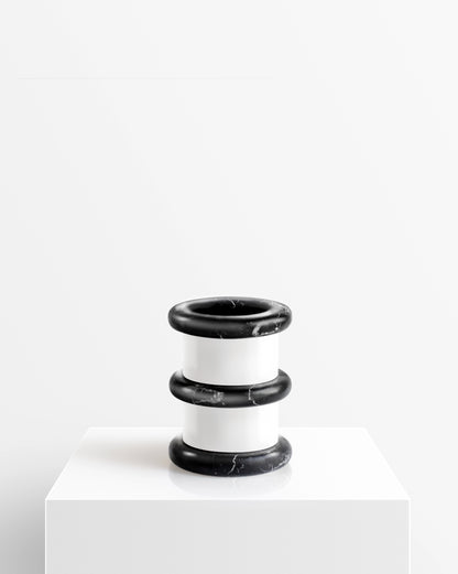 Black and white marble vase from the Lumière collection on a white pedestal