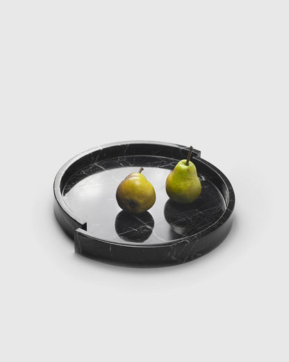 Two green pears in the black "Mistake" tray made from Nero Marquina marble, showcasing its elegant and mismatched design.