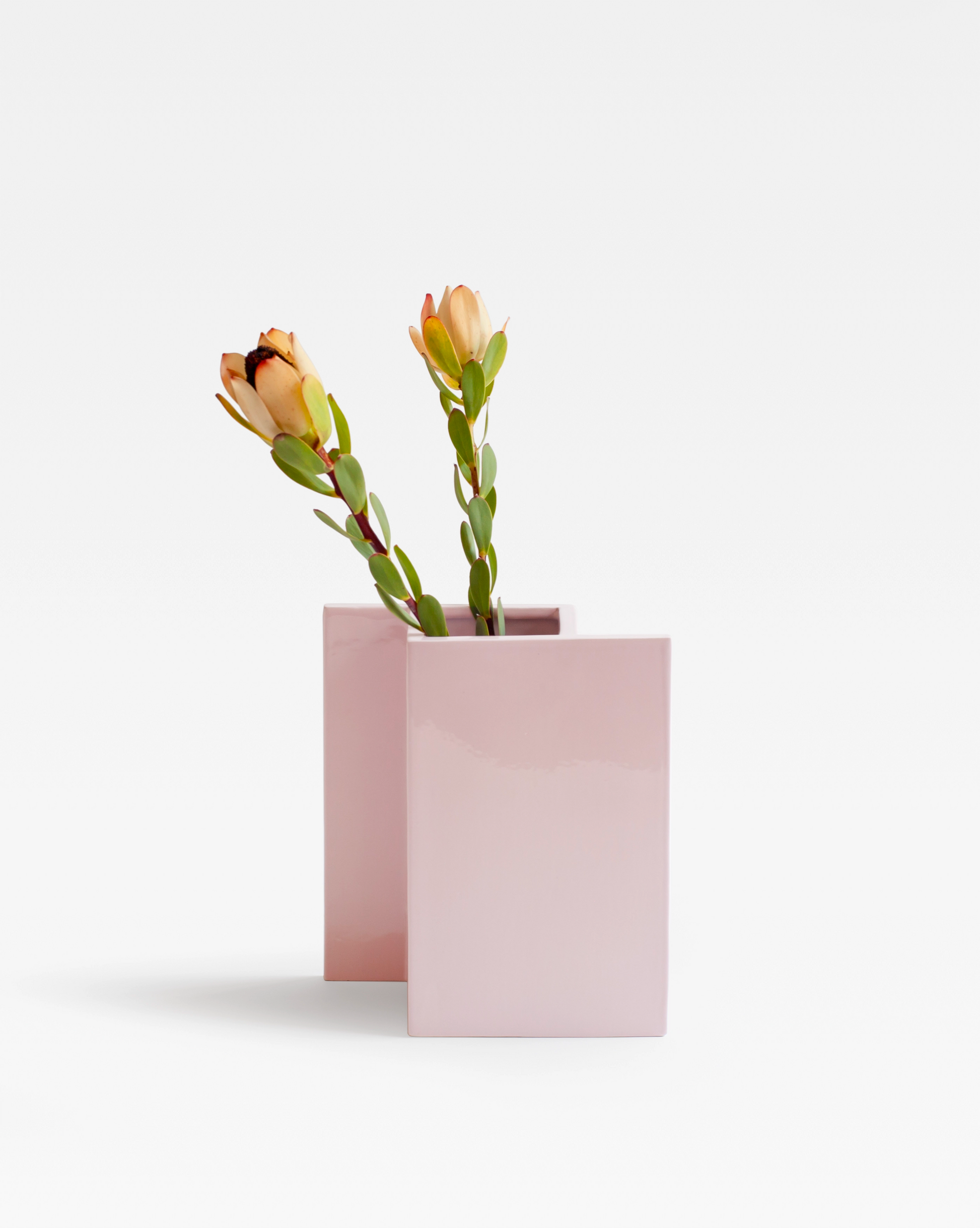 The geometric handcrafted pink ceramic vase by Sandro Lopez inspired by the game of chess, modern, playful with flowers.