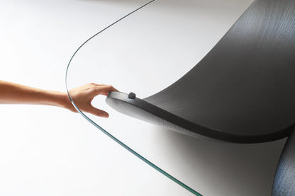 Detail of a hand touching the edge of the luxury sculptural coffee table designed for artful interiors.