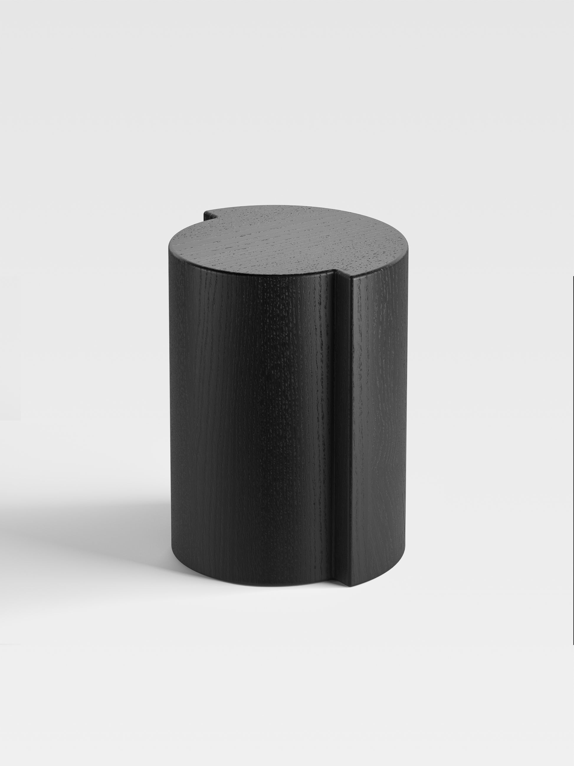 Angled view of Lei black oak side table showing soft sculptural form and premium craftsmanship from Milan.