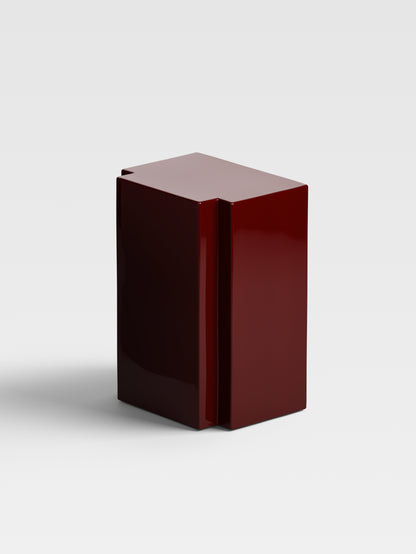 Angled view of Lui in burgundy, showing handcrafted high-gloss finish and minimalist geometry for collectible Milanese furniture.